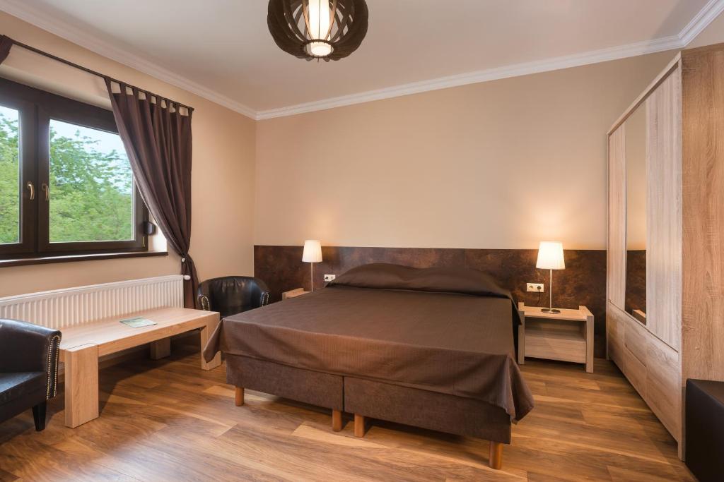 1 dormitorio con cama, mesa y sofá en Harangvirág Apartmanház - Visegrád, en Visegrád