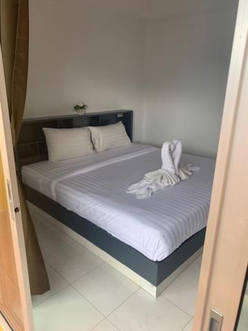 - une chambre dotée d'un lit avec des draps blancs dans l'établissement Calypso Patong House, à Patong Beach