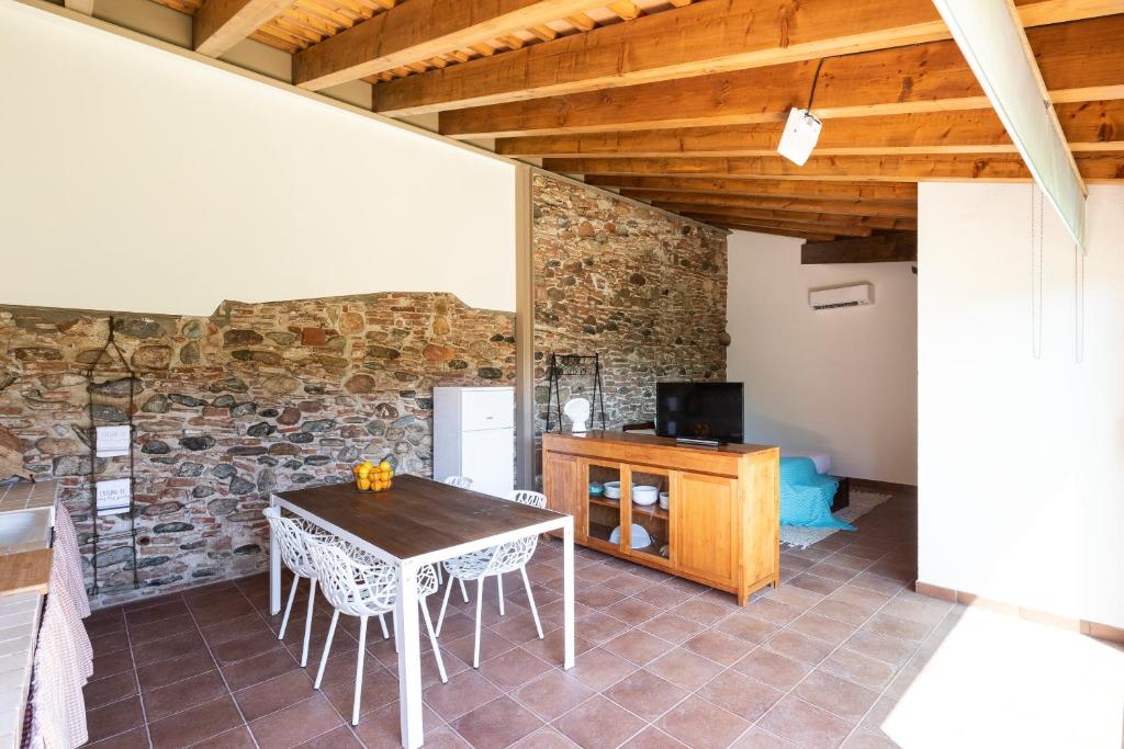 uma sala de jantar com uma mesa e uma parede de pedra em RUSTIC & CHIC b&b em Granollers