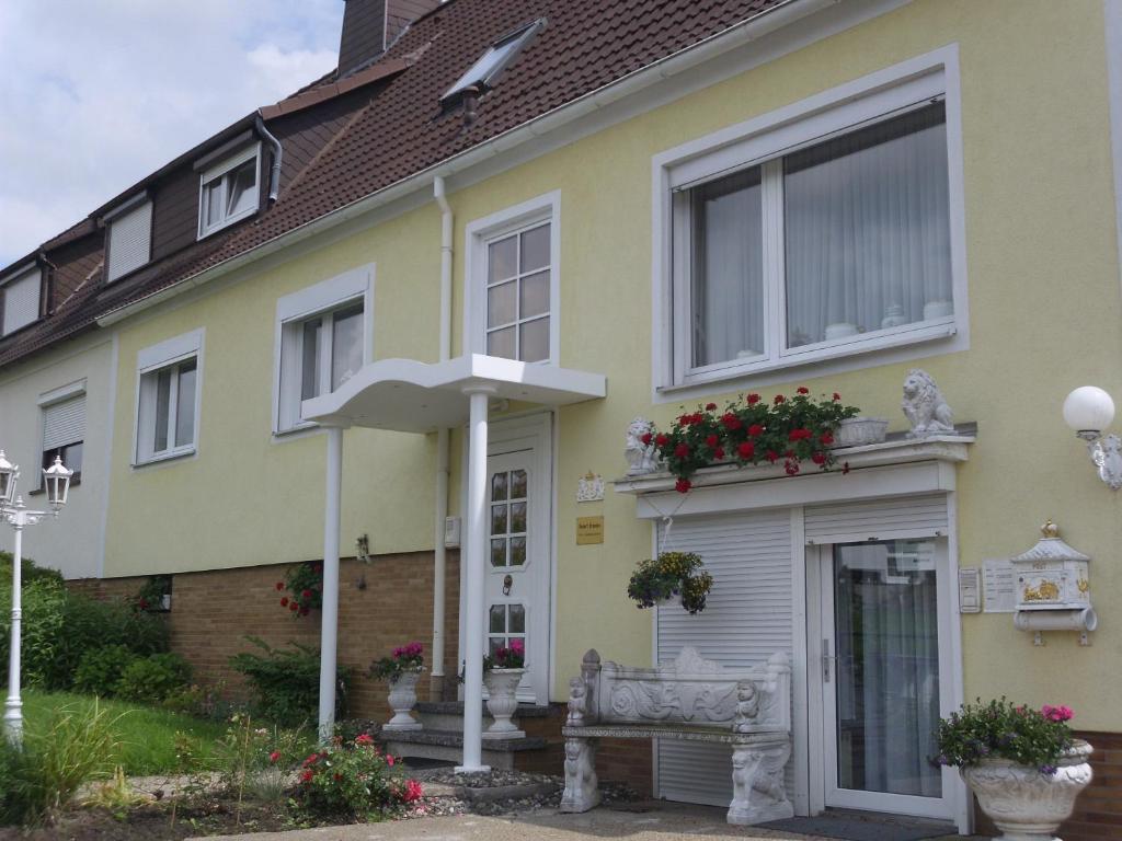 una casa amarilla con banco y sombrilla en Ferienwohnungen Hildegund, en Uschlag