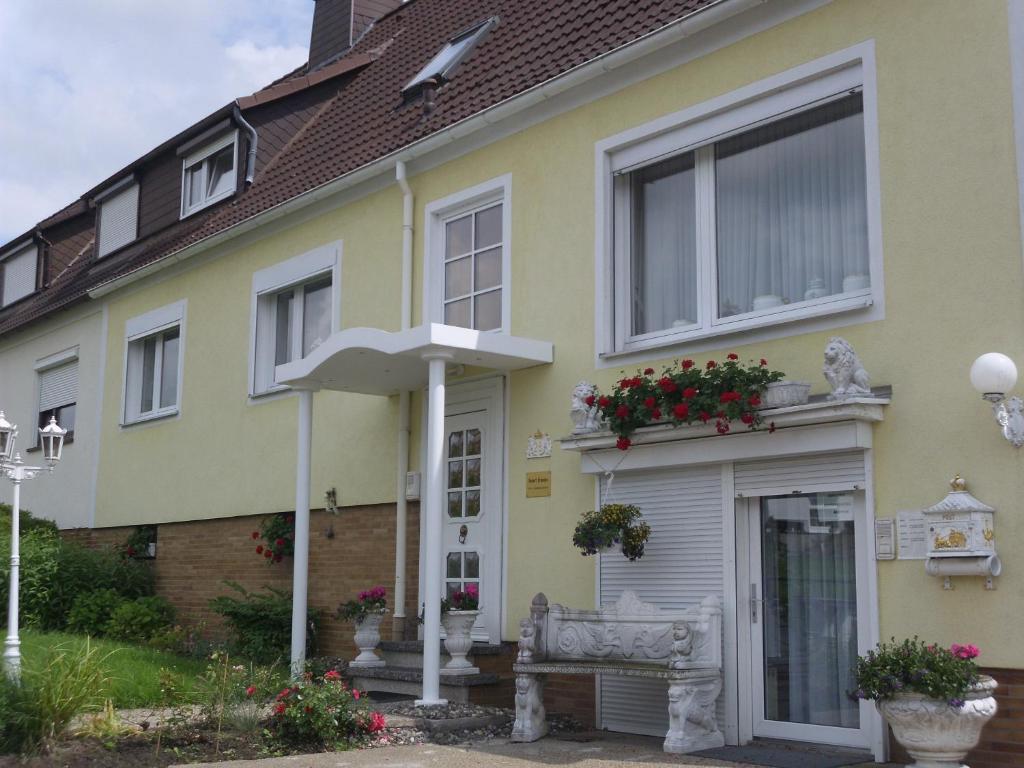 una casa gialla con panchina e ombrellone di Ferienwohnungen Hildegund a Uschlag