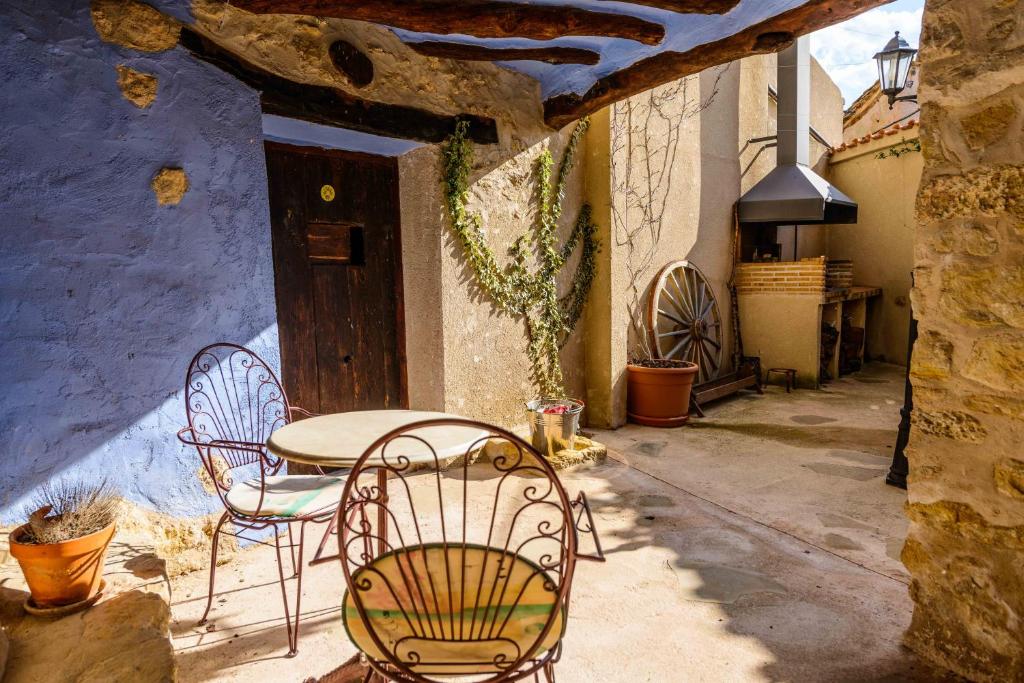 un patio con tavolo e sedie in un edificio di Casa rural Lo Regolfo a La Codoñera
