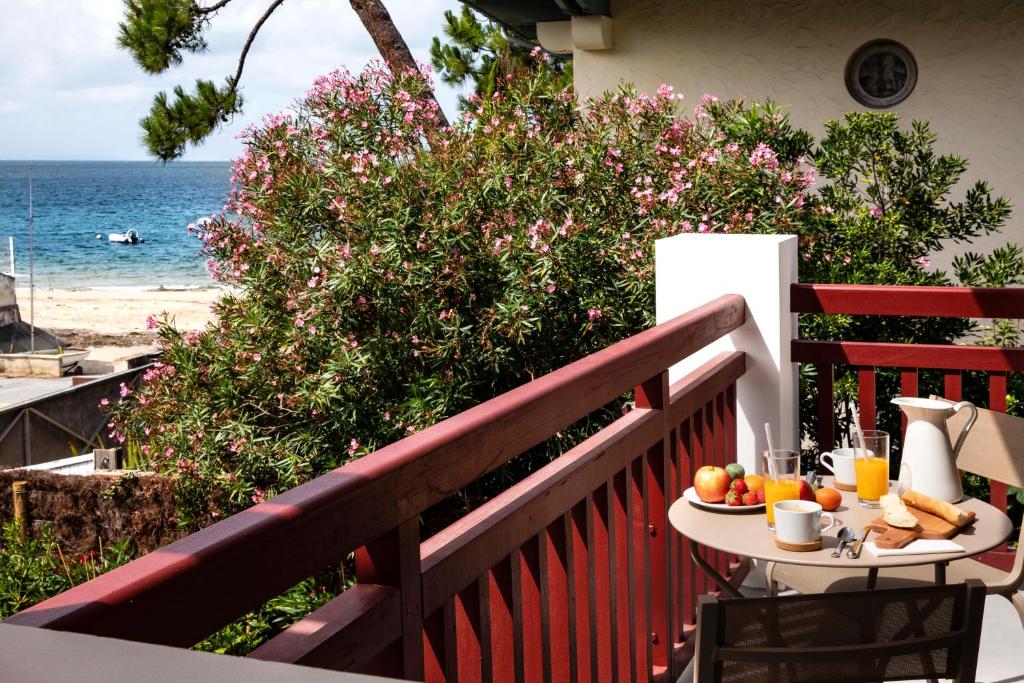 a table with fruit on a balcony with the beach at Villa du Pyla in Pyla-sur-Mer