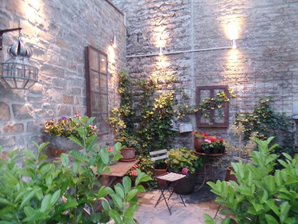 Charming Holiday Home with Terrace في Tilff: فناء بالنباتات وجدار من الطوب