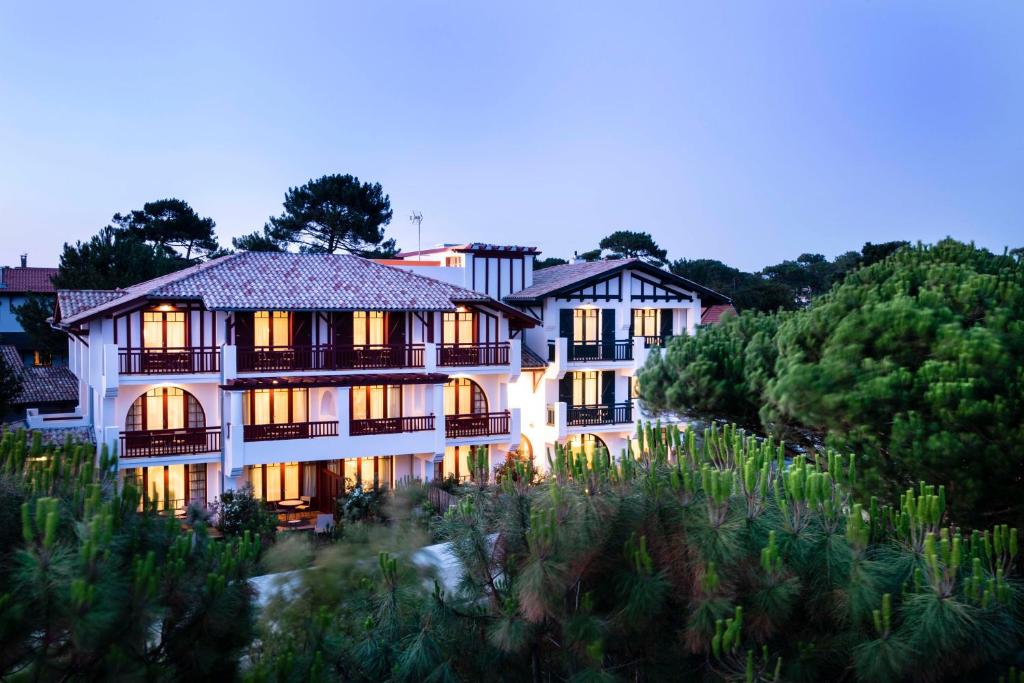 a large white building with its lights on at Villa du Pyla in Pyla-sur-Mer