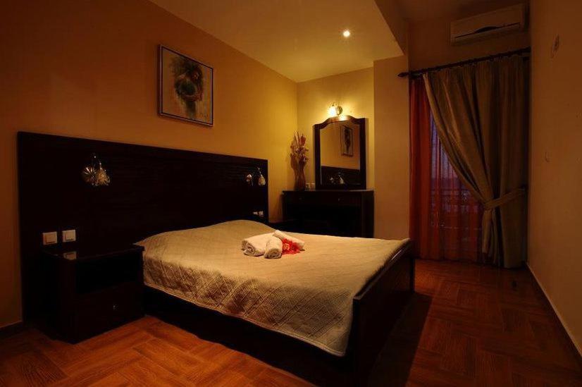 NerotriviáにあるPantheon Hotel & Suitesのベッドルーム1室(ベッド1台、鏡、窓付)