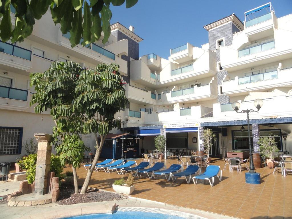a hotel with chairs and tables in front of a building at Playamarina 2 Reception Cabo Roig in Playas de Orihuela
