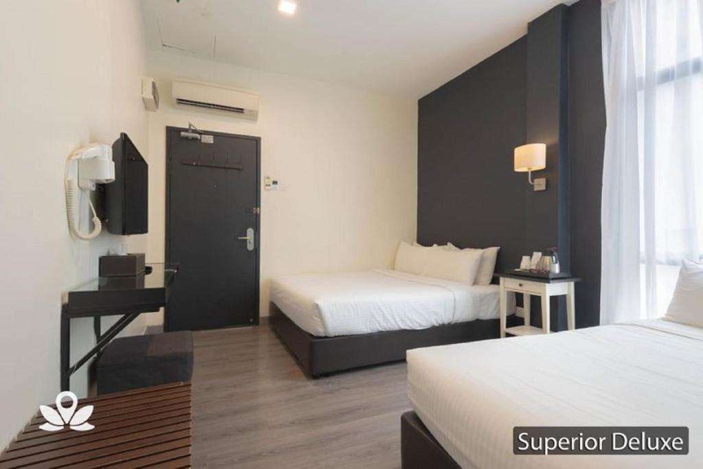 A Superior Deluxe twin room with two beds, a window, and a small entry-side work area.