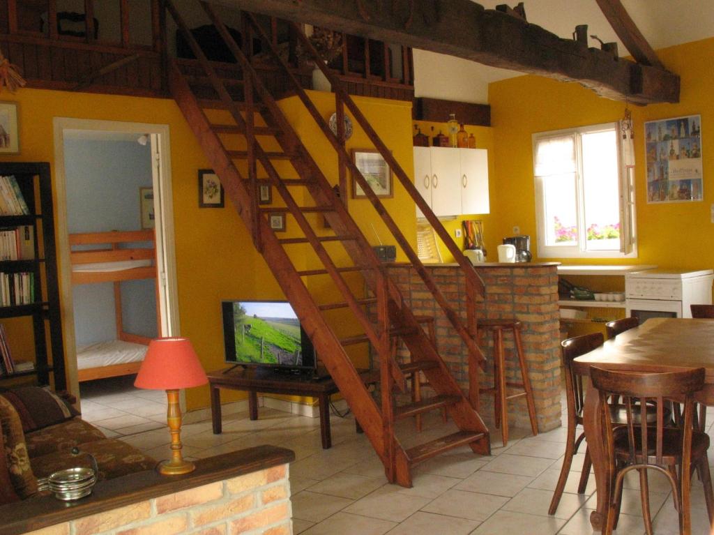 a living room with a wooden staircase in a house at Gite Rural Entre Terre et Mer in Widehem