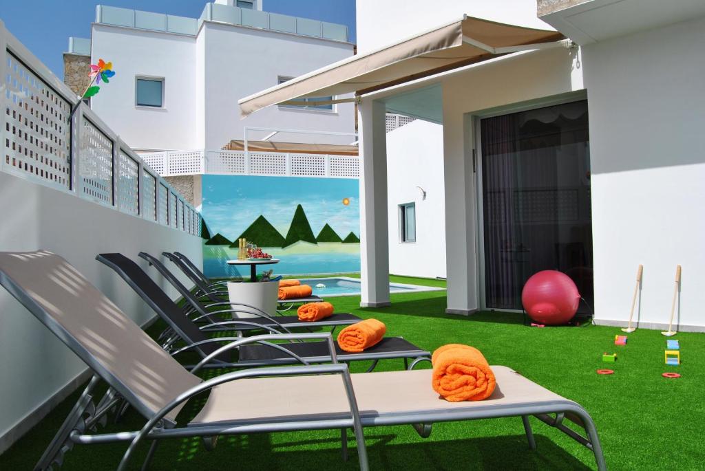 d'un balcon avec des chaises et une pelouse verdoyante. dans l'établissement Big Villa Tauro with Private Heated Saltwater Pool & jacuzzi & BBQ & Game Room, à Mogán
