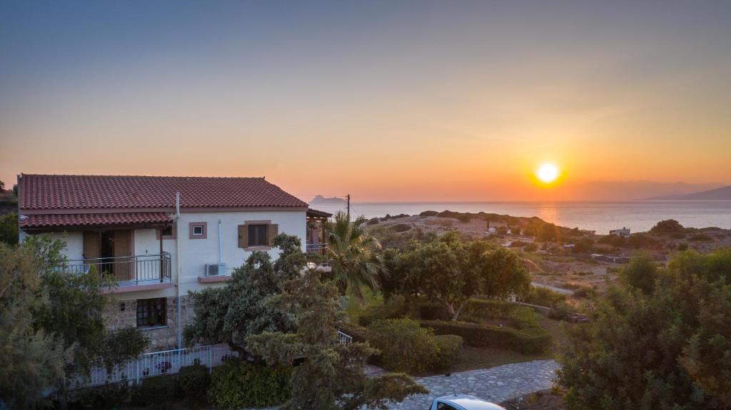 a house with the sunset in the background at Irene Komos in Pitsidia