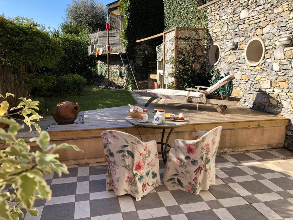 a patio with a table and chairs and a wooden deck at Al Canevelli 1 in Zoagli