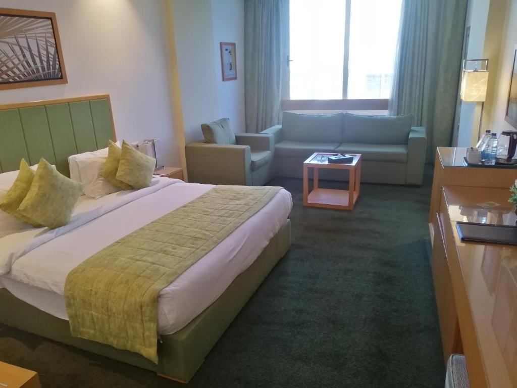 a hotel room with a bed and a couch at Tolip El Narges in Cairo