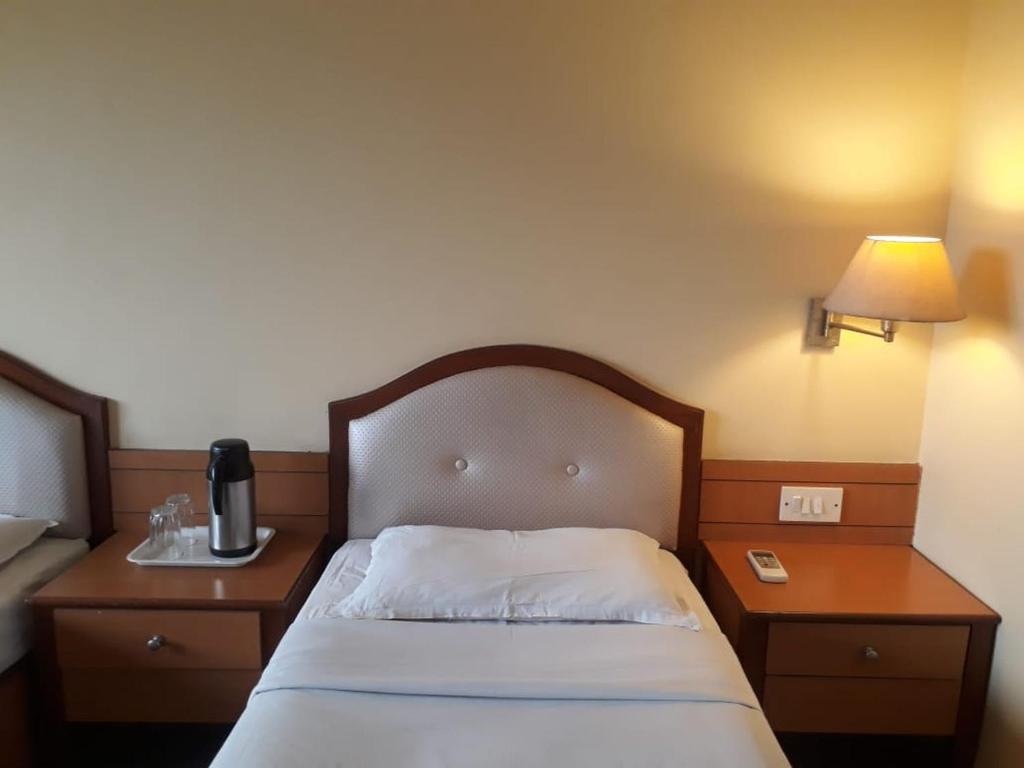 Postel nebo postele na pokoji v ubytování The Samrat Hotel near Pune Railway Station