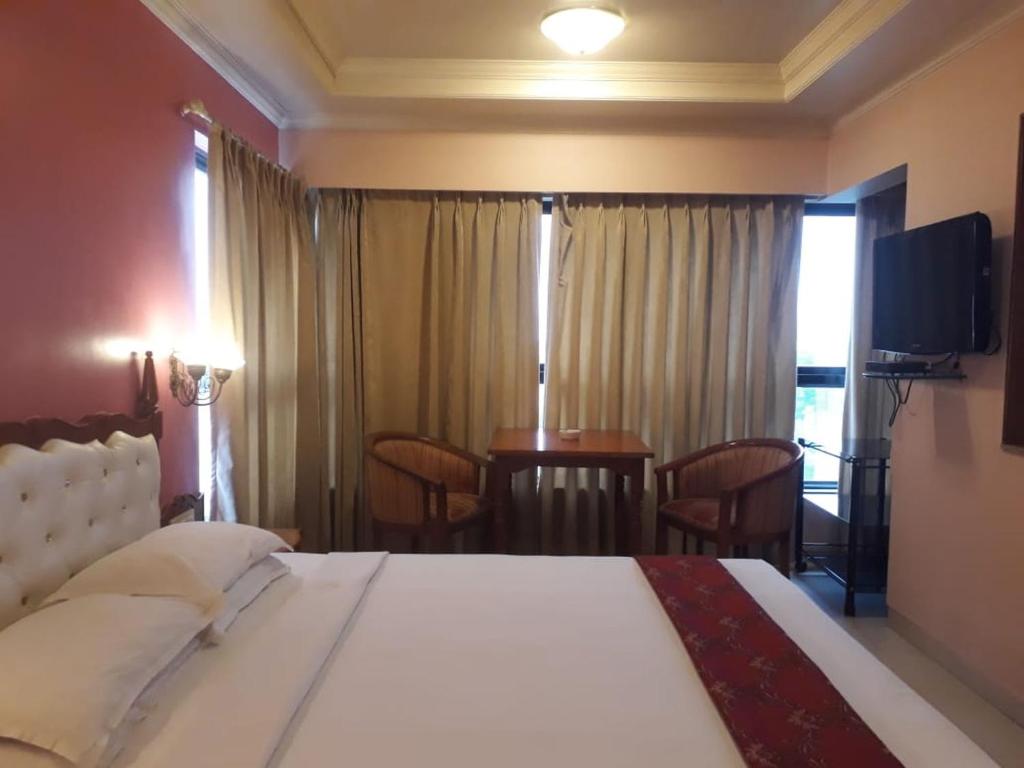 Postel nebo postele na pokoji v ubytování The Samrat Hotel near Pune Railway Station
