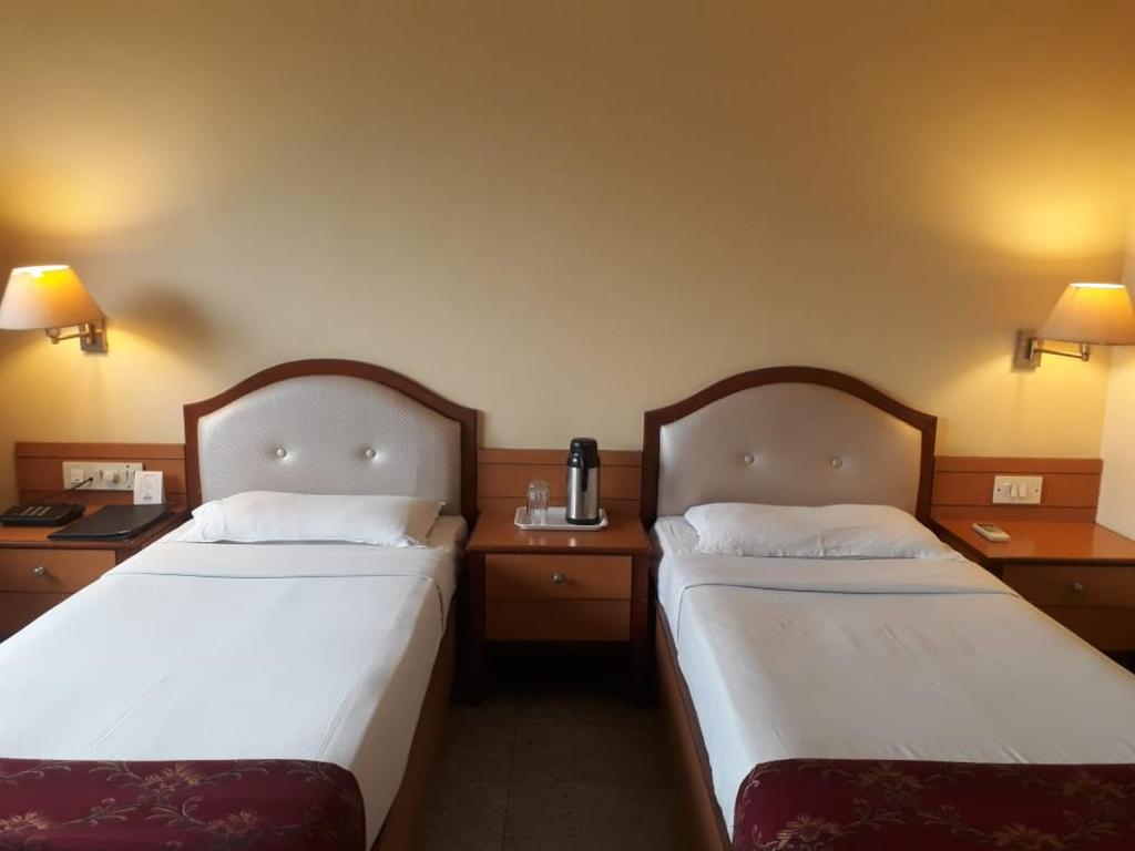 Postel nebo postele na pokoji v ubytování The Samrat Hotel near Pune Railway Station