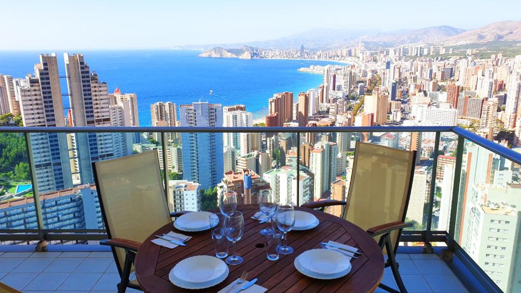 a table on a balcony with a view of the city at Torre Lugano Sea Views (Floor 28th) in Benidorm