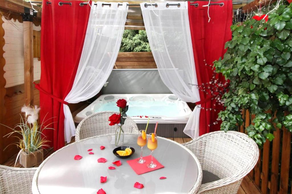 een witte tafel met een vaas met bloemen erop bij Escale Cocooning in Bruyères