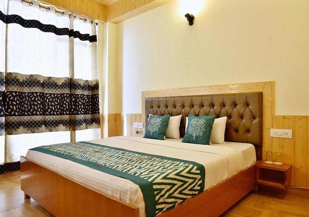 una camera con un grande letto e una finestra di Ditto Room Kufri Ashray a Shimla
