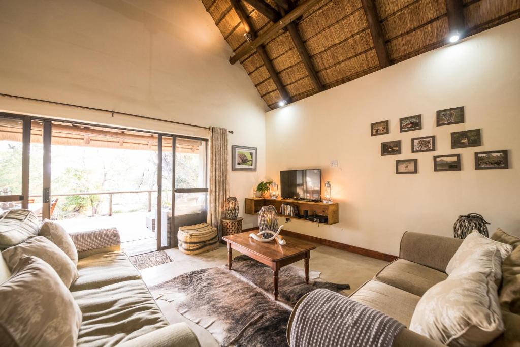 uma sala de estar com um sofá e uma mesa em Rukiya Safari Camp em Hoedspruit