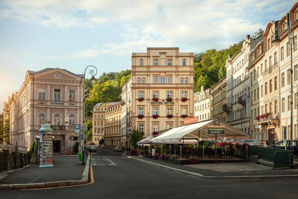 una calle de la ciudad con edificios altos y una calle con una calle en Hotel Ruze, en Karlovy Vary