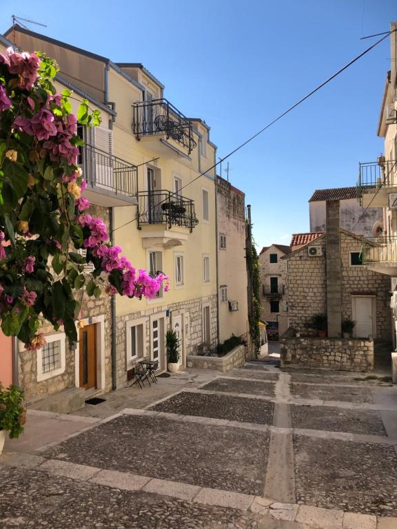 una strada vuota in un centro storico con fiori di Luxury City Center Apartments a Makarska