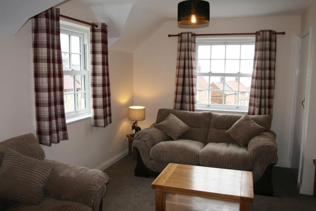 a living room with a couch and two windows at Hawthorn in Crayke YO61 4TE in York