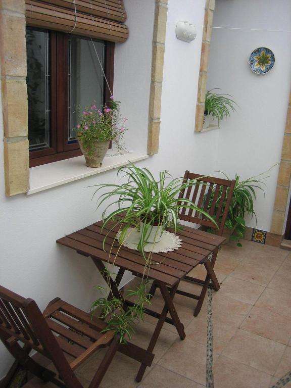 una mesa de madera y 2 sillas en el patio en Casa Rural La Villa, en Castro del Río