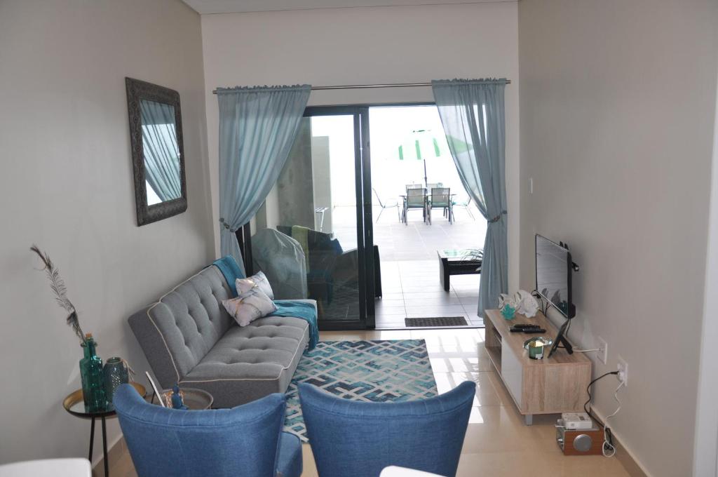 a living room with a couch and blue chairs at Azure Luxury Apartments Estate in La Mercy