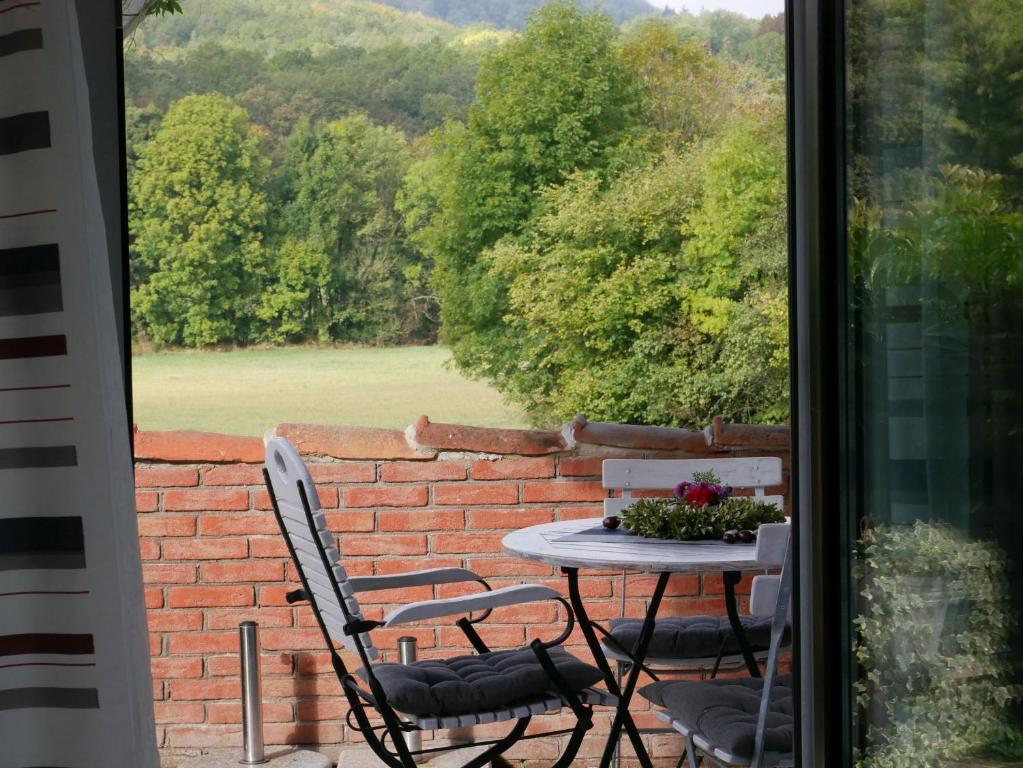 een tafel en stoelen op een patio met een bakstenen muur bij Ferienhaus Knodel in Sachsenheim