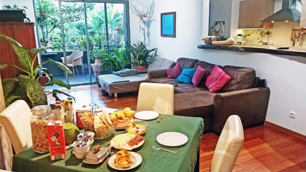 un soggiorno con tavolo e cibo sopra di Rochas Shared Apart Garden Refuge a Funchal