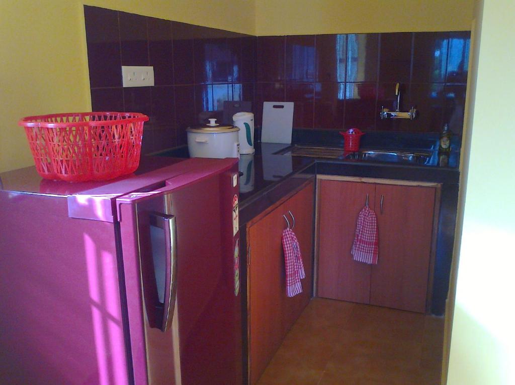 una cucina con frigorifero rosso e lavandino di Avalon Inn a Mandrem