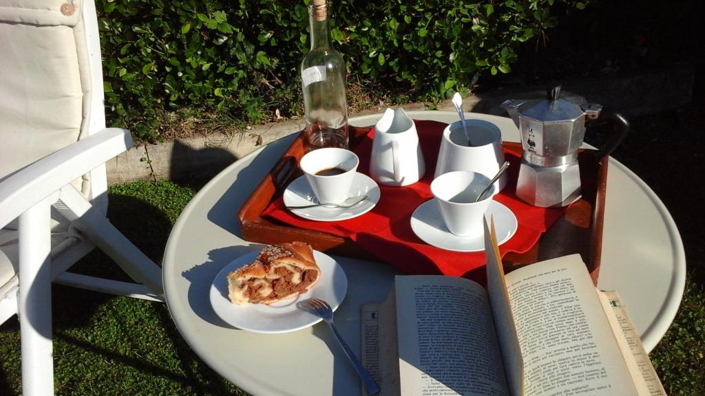 einen Tisch mit einem Teller Essen und einer Flasche Wein in der Unterkunft Casa Via Castelmonte in Cividale del Friuli