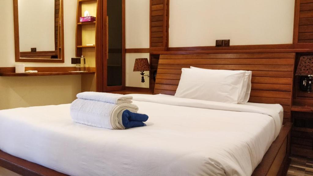 um quarto com uma cama com duas toalhas em Akiri Surf Retreat em Thulusdhoo