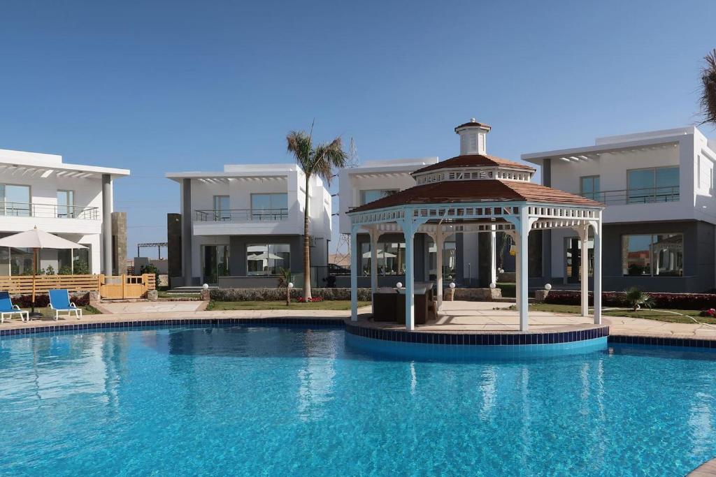 a swimming pool with a gazebo next to a building at Sky Star Villa 25 in Hurghada