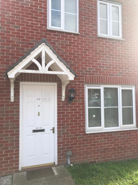 un edificio de ladrillo con una puerta y ventanas blancas en HOUSE shared, New Build 36 Nottingham 3bedrooms, en Nottingham