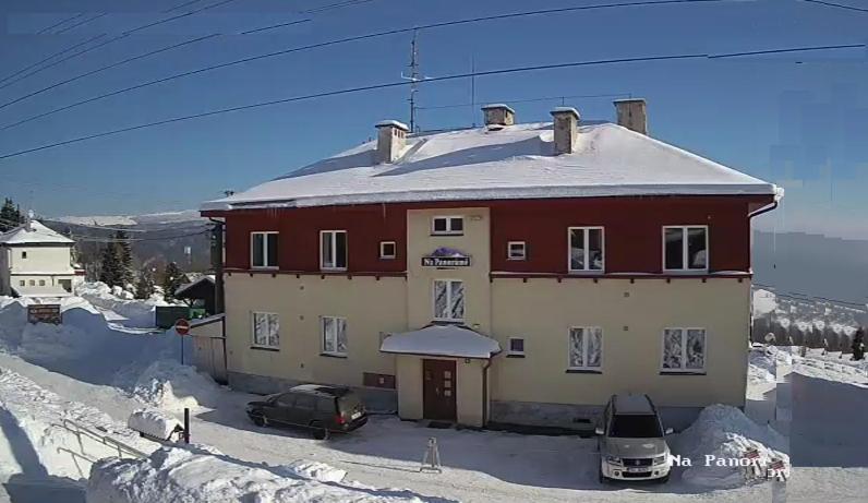 um grande edifício vermelho e branco na neve em Prázdninový dům Na Panorámě em Jáchymov