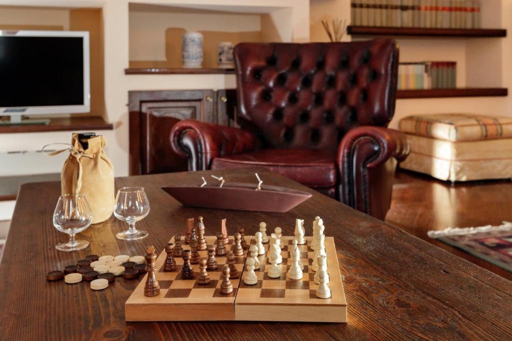 een schaakspel op een houten tafel in een woonkamer bij HelloChalet - Maison Paquier - Family Ski Holiday in the resort center in Valtournenche