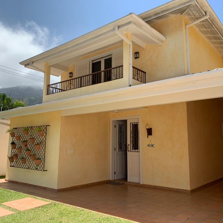a house with a balcony on top of it at Villa Mare Residence in São Sebastião