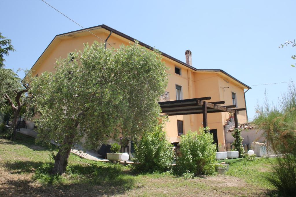 una casa naranja con un árbol delante de ella en La Casa delle Storie, en Teramo