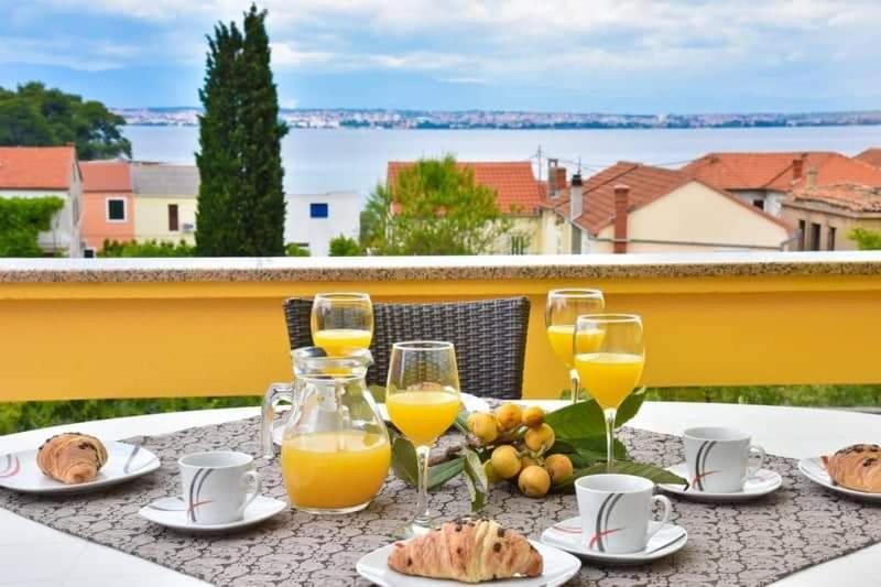 una mesa con vasos de zumo de naranja y comida en ella en Relax, en Preko