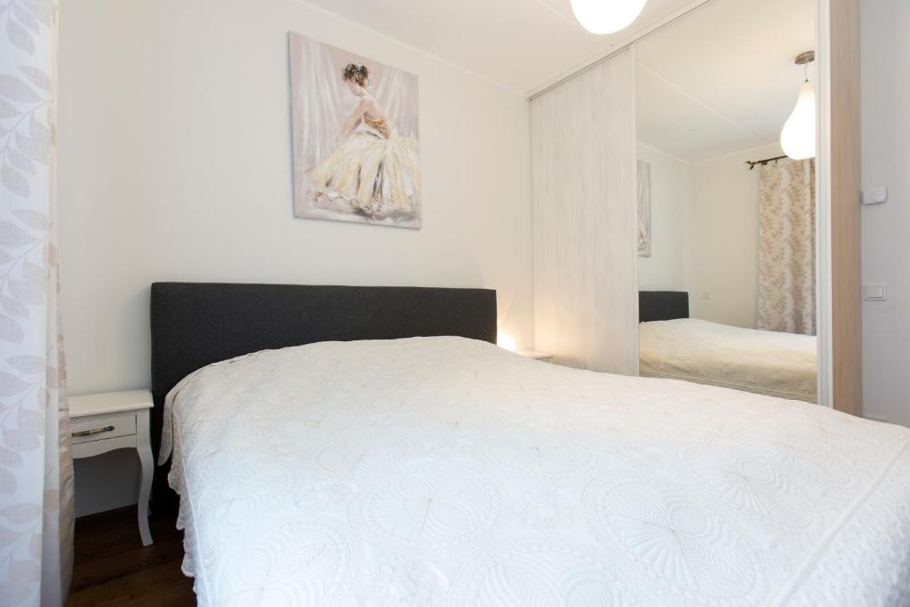1 dormitorio con cama blanca y espejo en Tuukri residents, en Tallin