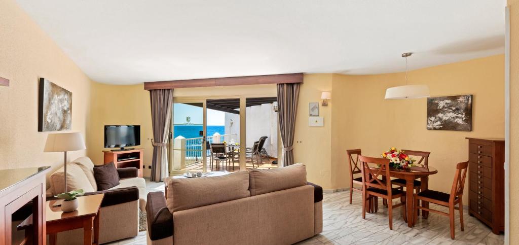 a living room with a couch and a table at Macdonald Leila Playa Resort in La Cala de Mijas