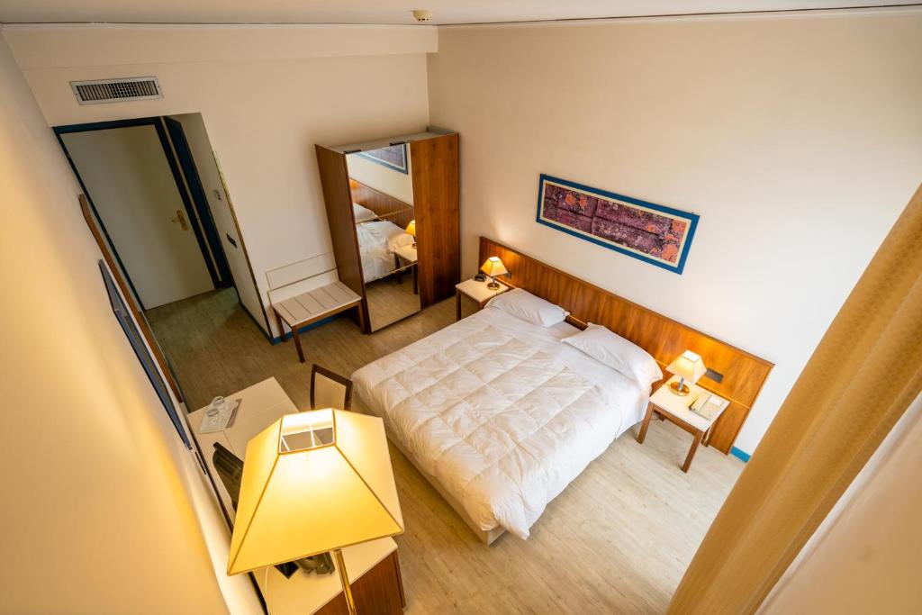 a small bedroom with a bed and a mirror at Europa Palace Hotel in Messina
