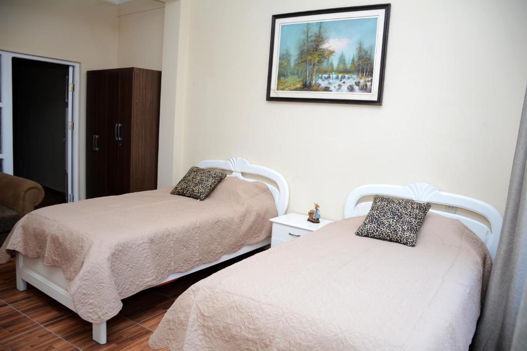 Habitación con 2 camas y una foto en la pared. en Hotel Apartamentos "Dominó", en Tarija