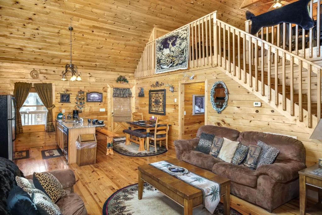 ein Wohnzimmer mit einer Treppe in einem Blockhaus in der Unterkunft Deer Run in Sevierville