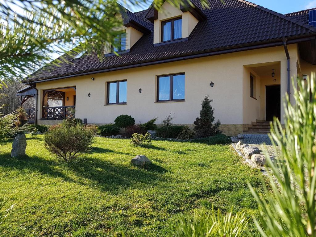dom z trawnikiem przed nim w obiekcie Kamienna Polana w Szczytnej