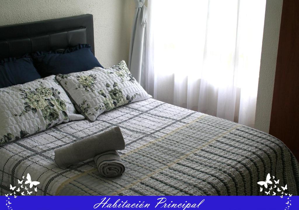 a bedroom with a bed with a blanket and pillows at Aloha in Bogotá