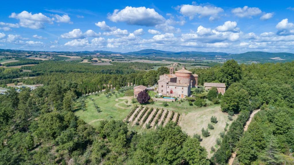 an aerial view of a castle on a hill with trees at Villa La Cappella in Monticiano