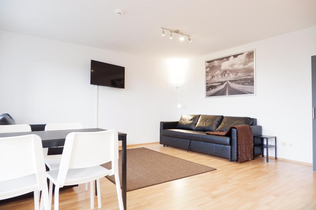 a living room with a couch and a table at Outletcity Apartment Ferienwohnung Metzingen in Metzingen